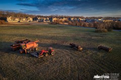 Equipment used to harvest hay, corn, and soybeans on a suburban plot of farm land sits idle at the end of the season in the hay field with an apartment building now occupying what once was farmland. My Final Photo for November 30, 2023. 