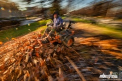 A landscaper uses a large lawnmower with its deck lowered to move thick piles of leaves off grass and sidewalk along Maxtown Road to a collection point for removal. My Final Photo for November 29, 2023. 