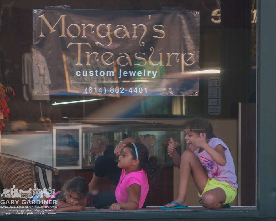 The grandchildren of Bill Morgan, a jeweler in Uptown Westerville, entertains passersby from the front display window of his soon to open new storefront in Uptown.