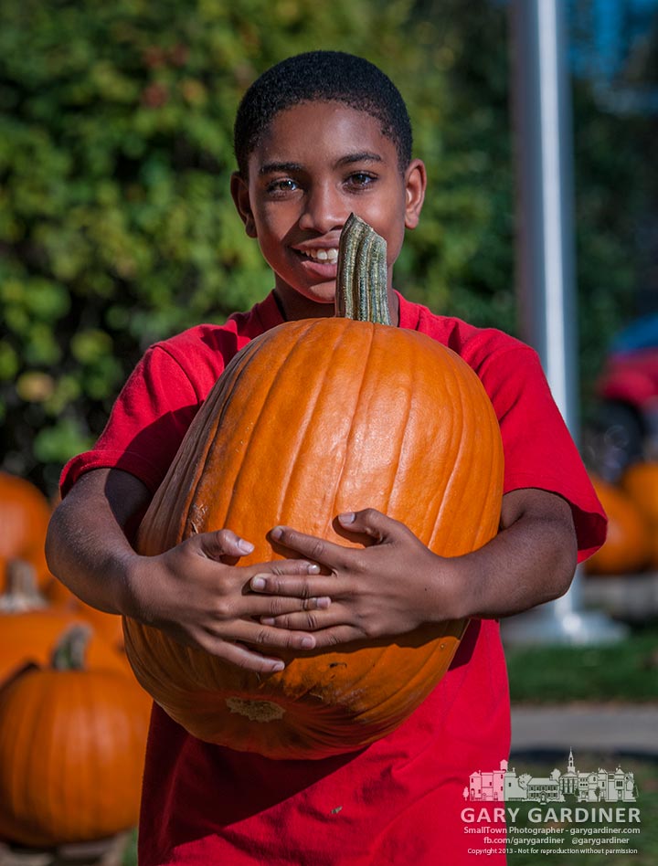 Twelve-year-old Tenderfoot Jaelon Gordon of Boy Scout Troop 560 carries a customer's pumpkin to their car at the troops pumpkin patch sales lot in the front yard at the Masonic Temple on State Street in uptown Westerville. My Final Photo for Oct. 8, 2013.