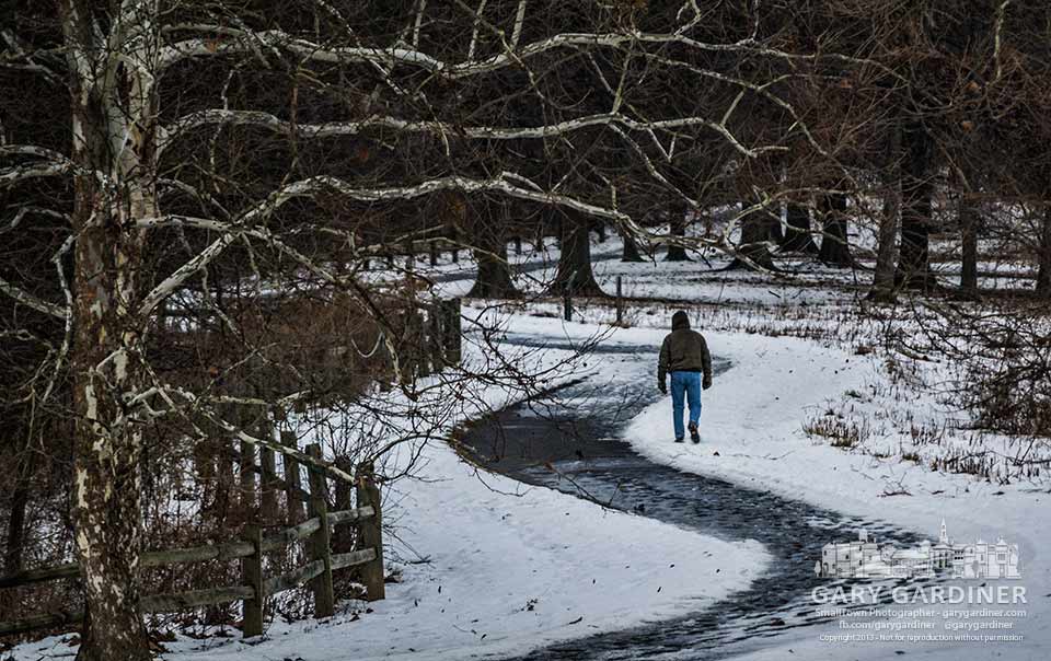 A hiker walks on the snow beside the slippery and dangerous ice-covered path beside the lake at Sharon Woods Park. My Final Photo for Dec. 15, 2013.