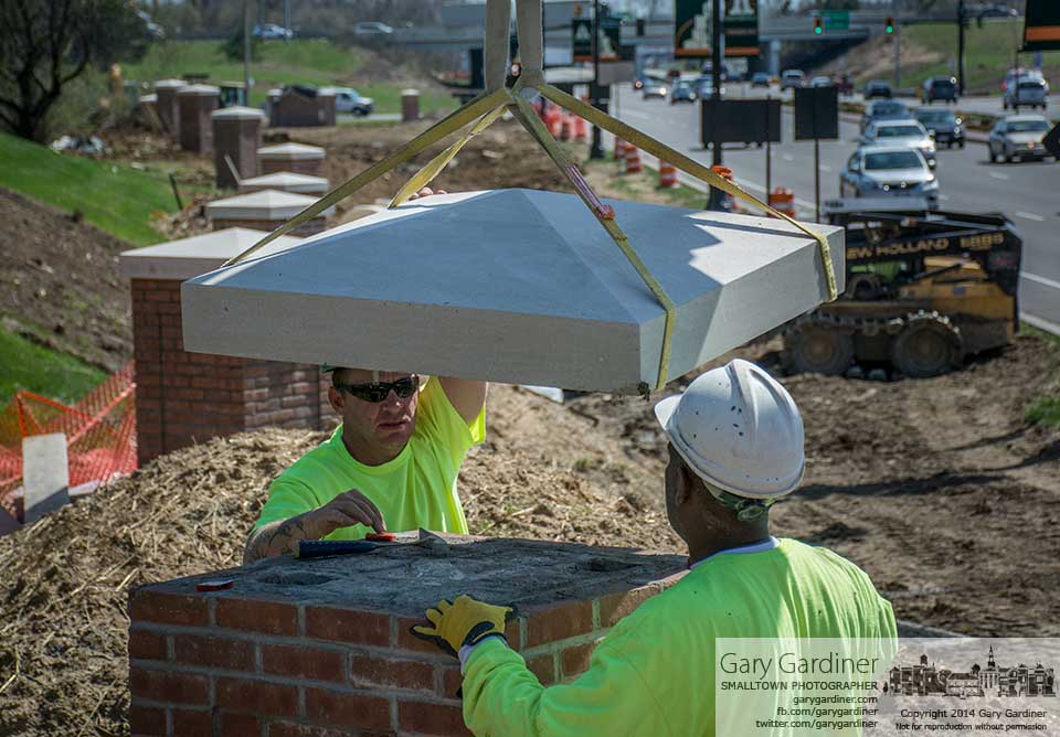 Brick masons install the concrete cap atop one of the decorative pillars being built along South State Street at I-270 as part of an improvement project for the entrance to the city. My Final Photo for April 17, 2014.