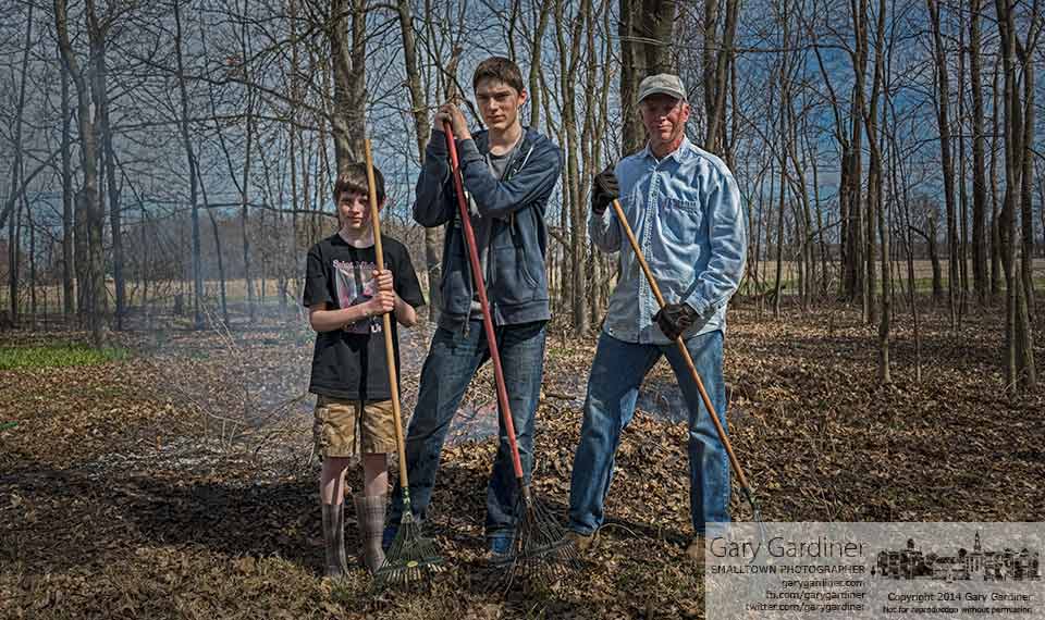 Father and sons stand in front of a pile of ash after burning brush from the woods at their rural home. My Final Photo for April 20, 2014.