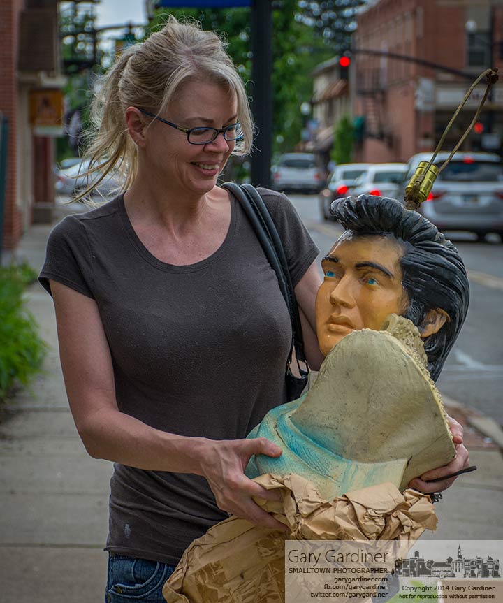 The top bidder carries away her Elvis lamp from the closed Foul Play Book Shop on East College . My Final Photo for May 12, 2014.