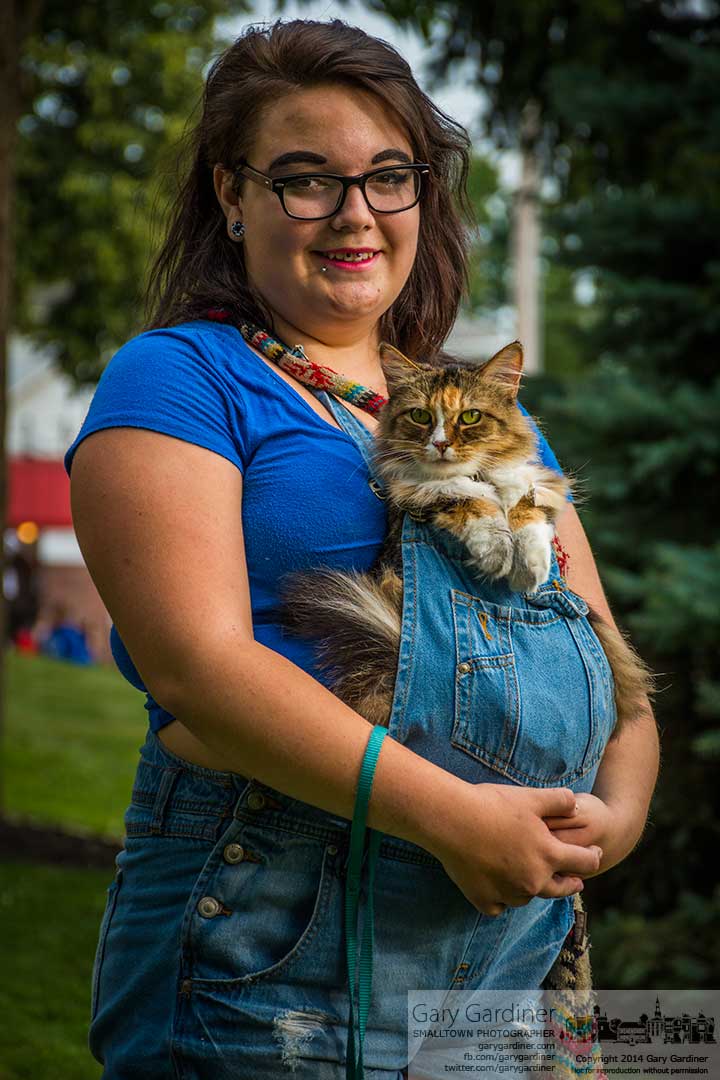 A young girl cradles her cat inside her overalls for a stroll through Fourth Friday in Uptown Westerville. My Final Photo for July 25, 2014.