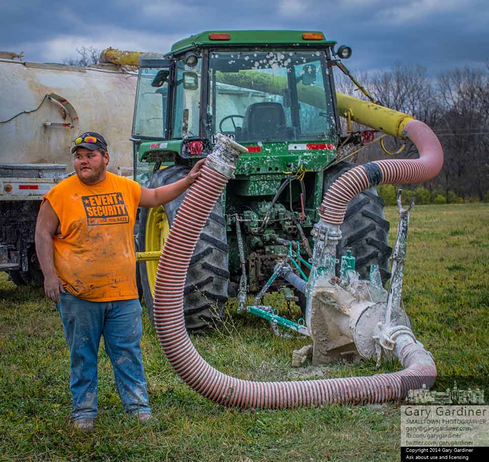 A farm worker waits with hose in hand for the arrival of a tanker truck with lime to be spread on the Braun Farm field after the last harvest of the season of hay and soybeans. My Final Photo for Nov. 11, 2014.