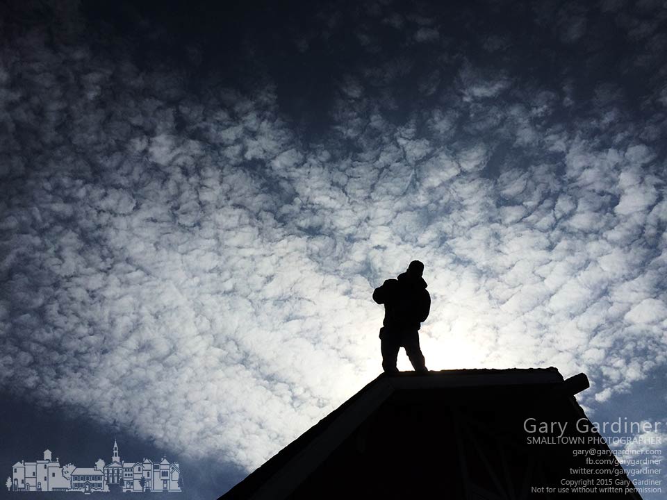A picker stands at the top of a barn after removing the cupolas before the building is demolished to make way for condos. My Final Photo for March 23, 2015.