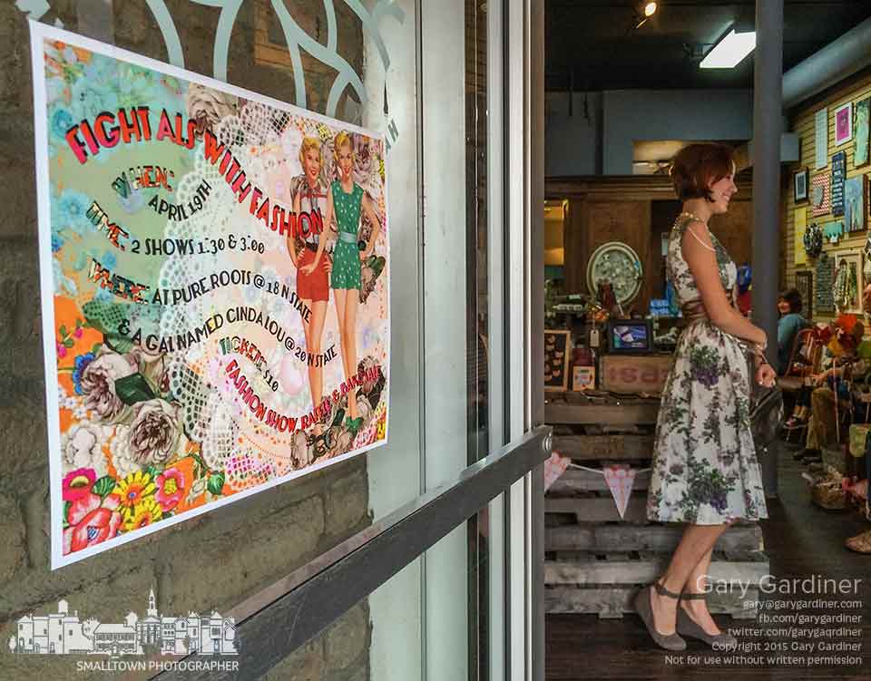 A model wearing a mid-century modern dress stands inside the doorway of Pure Roots in Uptown Westerville during a fashion show to benefit an ALS charity. My Final Photo for April 19, 2015.