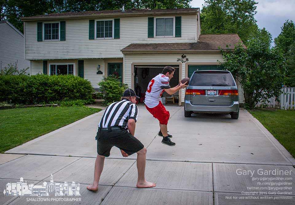 Two teens play a game of front yard football to practice plays and calls dressed as a player and referee. My Final Photo for May 30, 2015.
