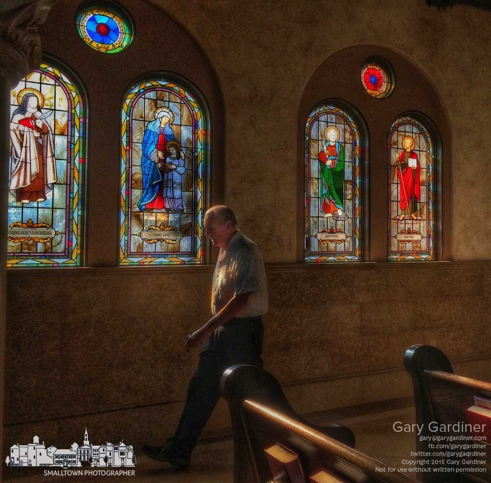 A parishioner walks past a set of stained glass windows in St. Paul Catholic Church after Sunday Mass. My Final Photo for June 7, 2015.
