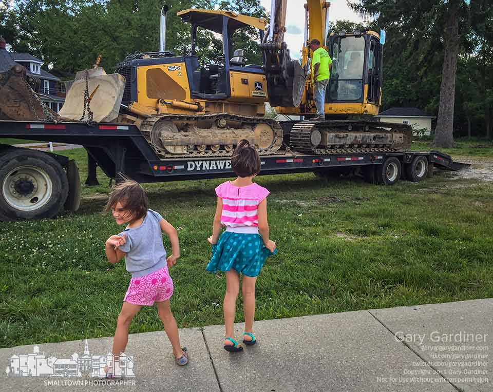Sisters jubilate with dance as they watch workers loading heavy equipment onto a flatbed trailer after clearing trees at the site for Northstar cafe in Uptown Westerville. My Final Photo for Aug. 12, 2015.