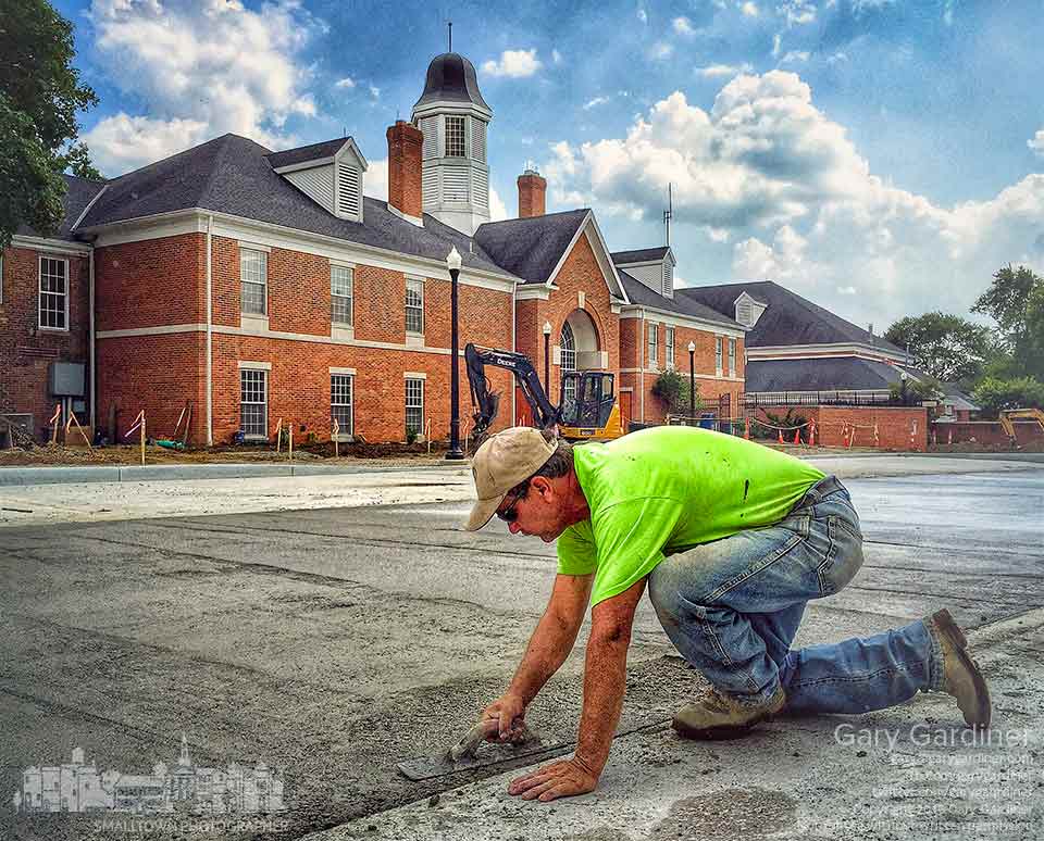 A contractor finishes a section of concrete in the new parking lot behind city hall before laying down a layer of brick to complete the job. My Final Photo for Sept. 8, 2015.