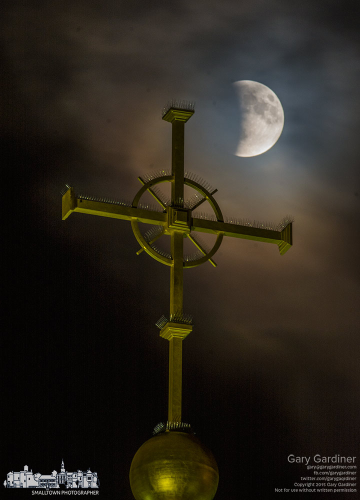The beginning of a super blood moon peeks through a bank of clouds that quickly obscured the remainder of a lunar eclipse behind the cross at the top of St. Paul Catholic Church in Westerville. My Final Photo for Sept. 27, 2015.
