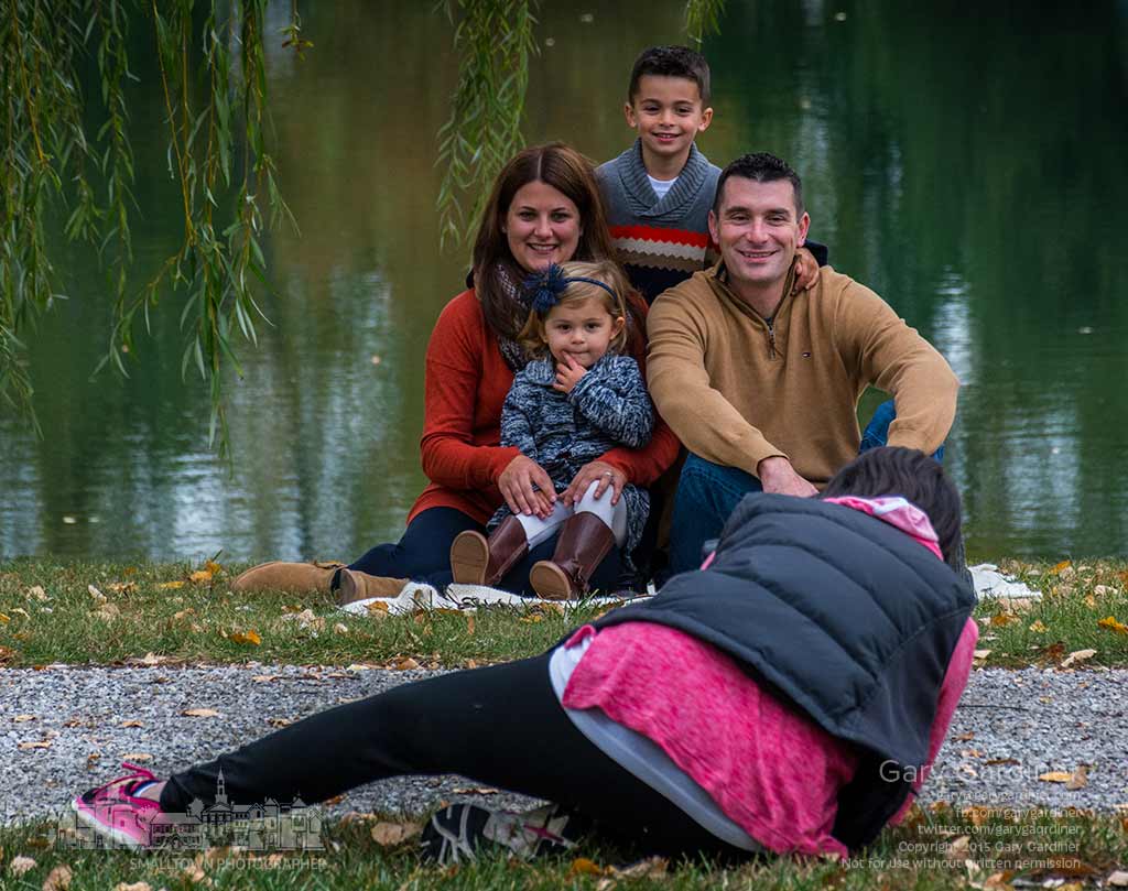 A portrait photographer distorts her body to get the best angle while creating photos for a family at Heritage Park in Westerville, My Final Photo for Oct. 24, 2015.