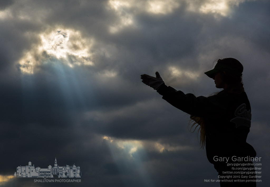 A student director for the marching band at Westerville Central i silhouetted against streaks of sunlight breaking through late afternoon clouds as she performs her duties during practice in one of the school's parking lots. My Final Photo for Oct. 13. 2015