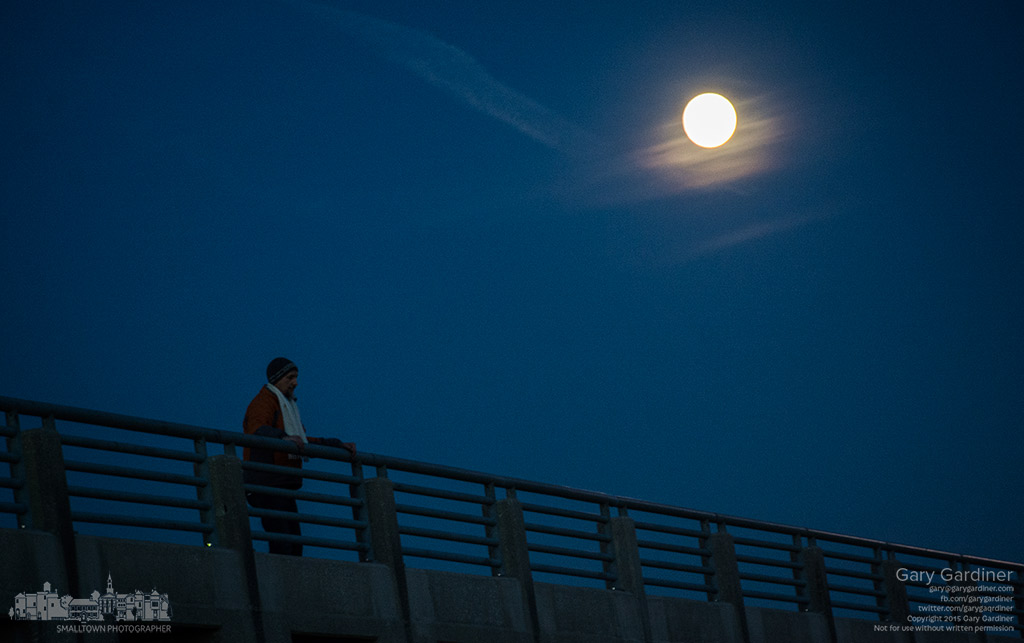 A man walking his dog across Hoover Dam pauses along the railing as a near full moon rises in the crisp early night light. My Final Photo for Nov. 24, 2015.