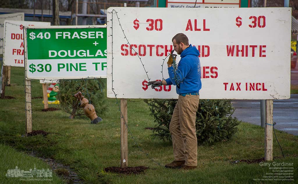 A worker removes strings of Christmas lights from the small billboard advertising tree sales lot at Glengary Center on Westerville Road as the lot closes for the season. My Final Photo for Dec. 22, 2015.