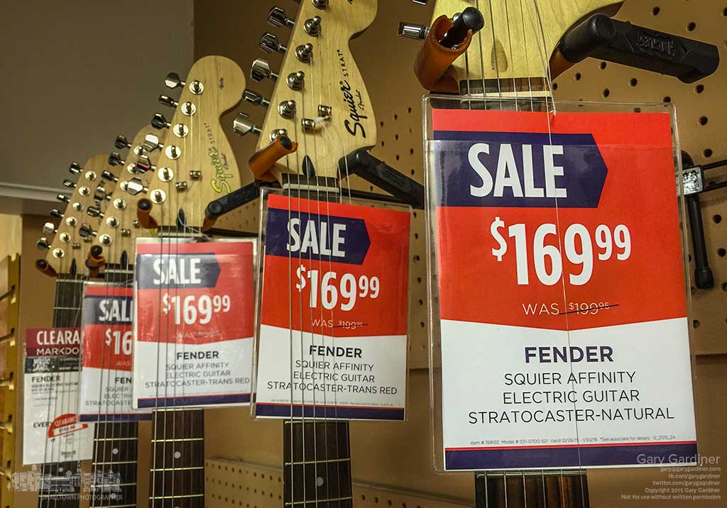 A collection of guitars are marked with discount sales prices at Uptown Music and Arts on the first day of the weekend after Christmas. My Final Photo for Dec. 27, 2015.