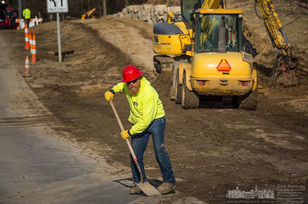 A construction worker clears Hempstead Road of debris after completing the installation of a new retaining wall along the edge of what will be a new bike path along the road., My Final Photo for January 28, 2016.