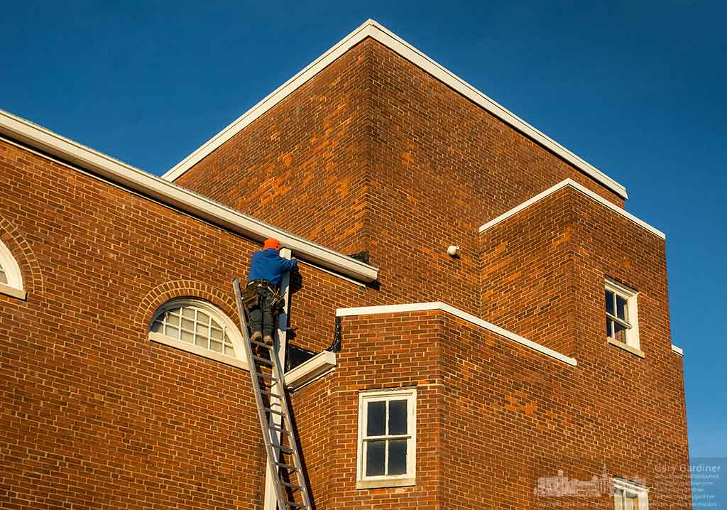 A gutter repair work crew replaces the old rusting gutters at the Masonic Hall with modern, more serviceable materials. My Final Photo for January 7, 2016.