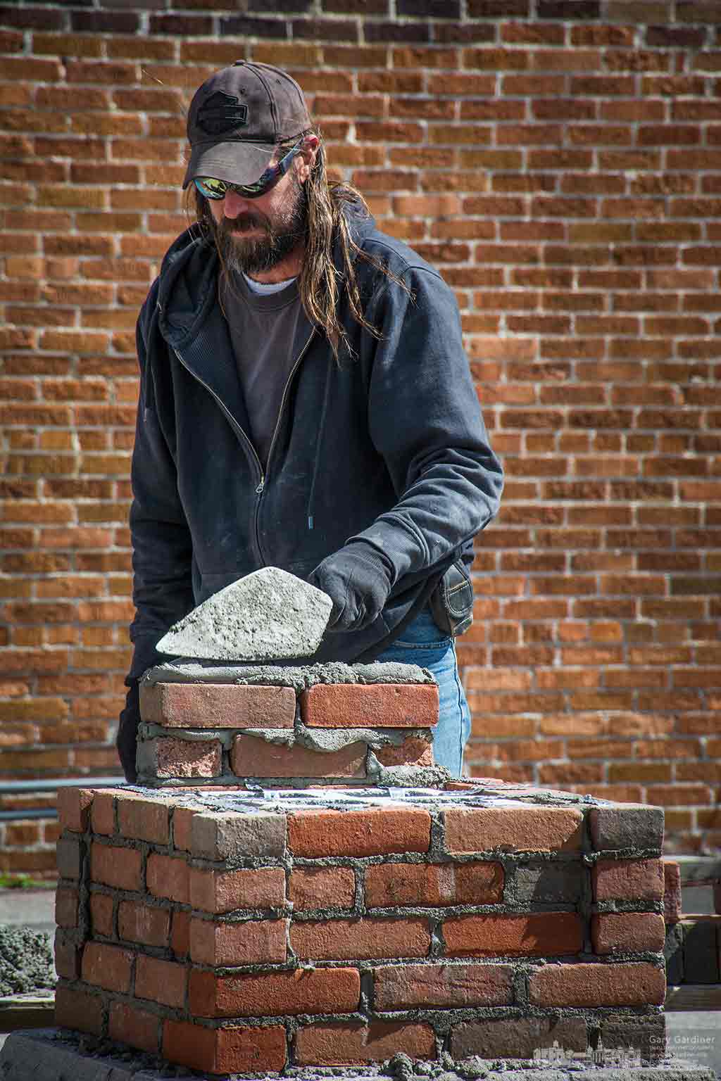Bricklayer adds another layer to one of the corner posts that will mark the entrance to the new parking lot behind city hall. My Final Photo for March 16, 2016.