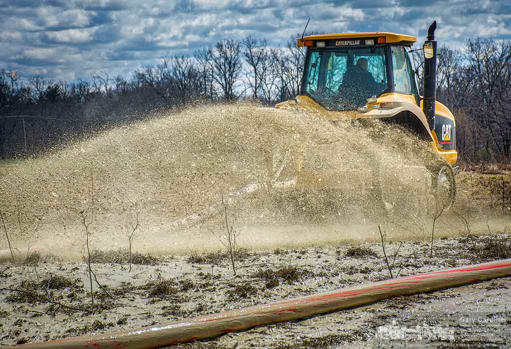 A tractor pulls a hose across the fields near the Braun Farm spreading lime from the holding pond at the Westerville city water treatment plant. My Final Photo for March 21, 2016.