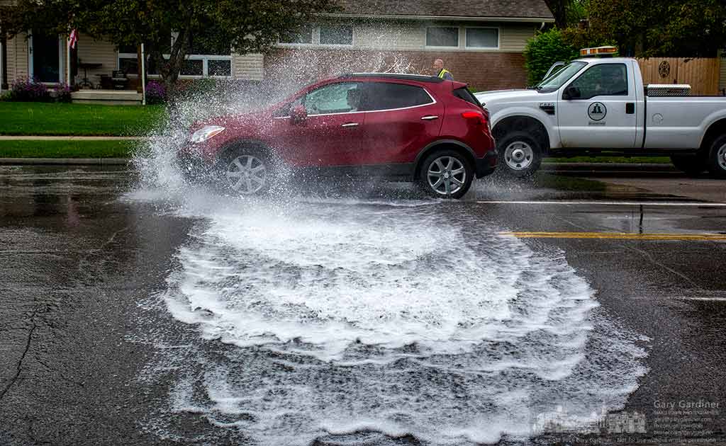 A woman drives her car through the powerful stream of water coming from a fire hydrant being flushed and tested on County Line Road. My Final Photo for May 3, 2016.