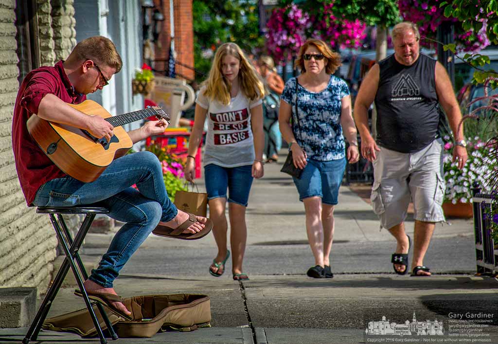 A guitarist tunes his instrument before beginning performing on the sidewalks in Uptown Westerville as part of the first night of the Westerville Music and Arts Festival. My Final Photo for July 8, 2016.