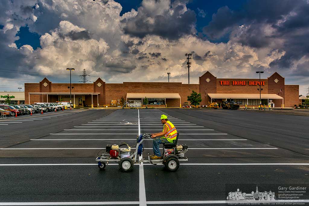 Worker paints stripes on the new parking lot at Home Depot on Maxtown Road after a major section of the lot was resurfaced and the entrance rebuilt. My Final Photo for August 18, 2016.
