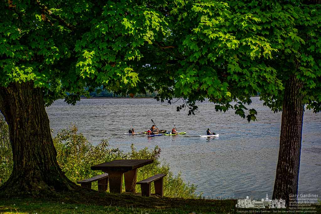 A trio of kayakers, two of them towing kids on their own kayaks, travel past Red Bank Harbor and its picnic area on Hoover Reservoir. My Final Photo for August 6, 2016.