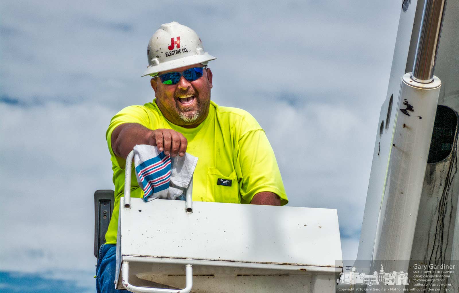 A crane operator breaks into a smile when on the receiving end of joke by his coworker as they install new light poles on State Street near Schrock. My Final Photo for August 16, 2016.