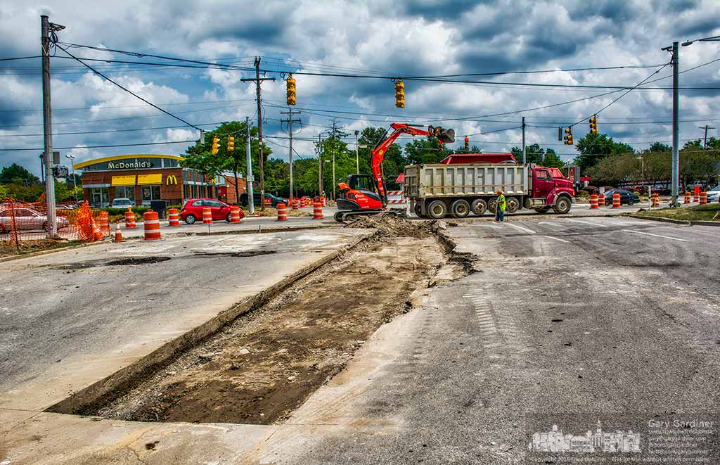 Construction workers fill the excavated curb with gravel at the closed State Street entrance to Kroger where a new, wider intersection will be built in the next several months. My Final Photo for August 9, 2016.