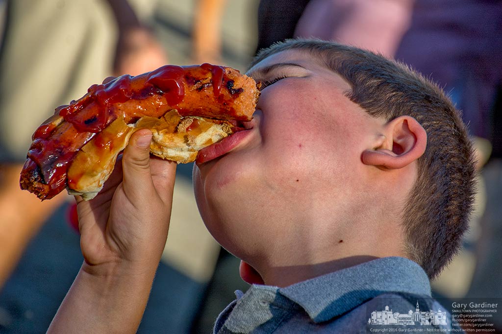 A youngster struggles with an oversized hot dog at the Westerville Food Truck Fest to benefit W.A.R.M. My Final Photo for Sept. 11, 2016.