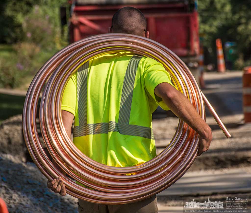 Contractor carrying coiled copper