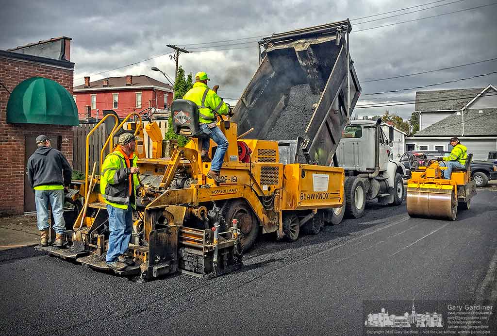 Workers finish paving the parking lot that runs from Winter Street to Slaughter Alley behind Java Central and the adjacent businesses as part of the addition of new parking places. My Final Photo for Oct. 27, 2016.
