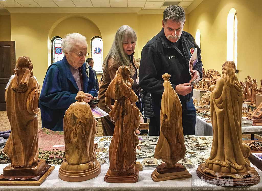 A family looks over rosaries and statues brought from the Holy Land for sale at Christmas at St. Paul Catholic Church. My Final Photo for Nov. 27, 2016.