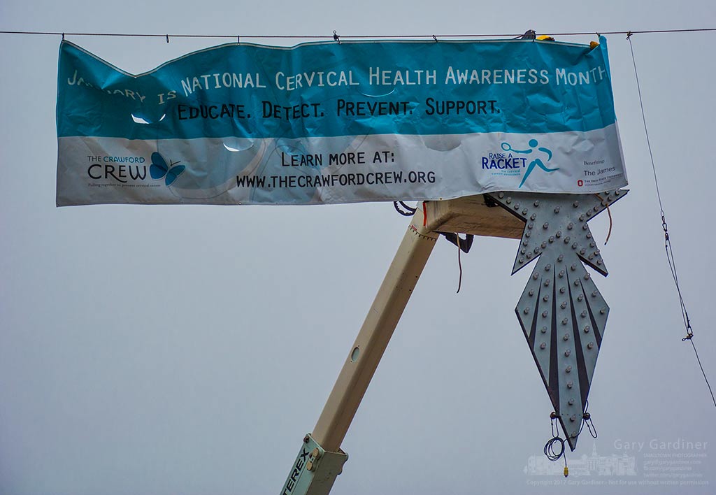 City workers install a banner for National Cervical Health Awareness Month while still holding onto the Christmas Star after its removal at State and Main. My Final Photo for Jan. 3, 2017.
