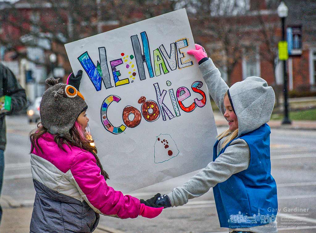 A pair of Girl Scouts share a banner advertising their cookies for sale on the sidewalk in Uptown Westerville. My Final Photo for Feb. 25, 2016.