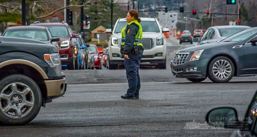 A Westerville police officer directs traffic near the center of the intersection of State and Schrock as electricians repair the traffic signal computer that placed red lights in all directions. My Final Photo for Feb. 7, 2017.
