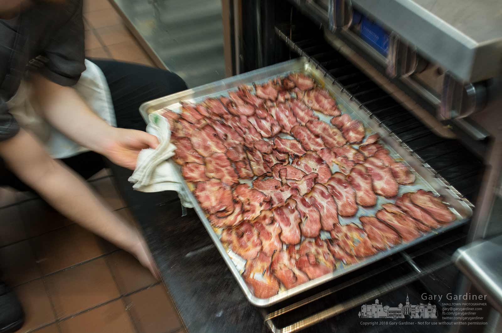 A cook removes a tray of pecan smoke pork shoulder bacon from an oven at Barrell & Boar in Uptown Westerville as the restaurant prepares for its opening. My Final Photo for Jan. 18, 2018.