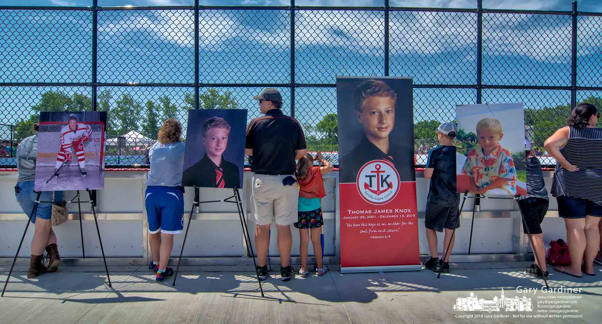 Photos of Thomas James Knox sit along the edge of the outdoor hockey rink dedicated in his name at ceremonies Saturday in Alum Creek Park South. My Final Photo for June 30, 2018.