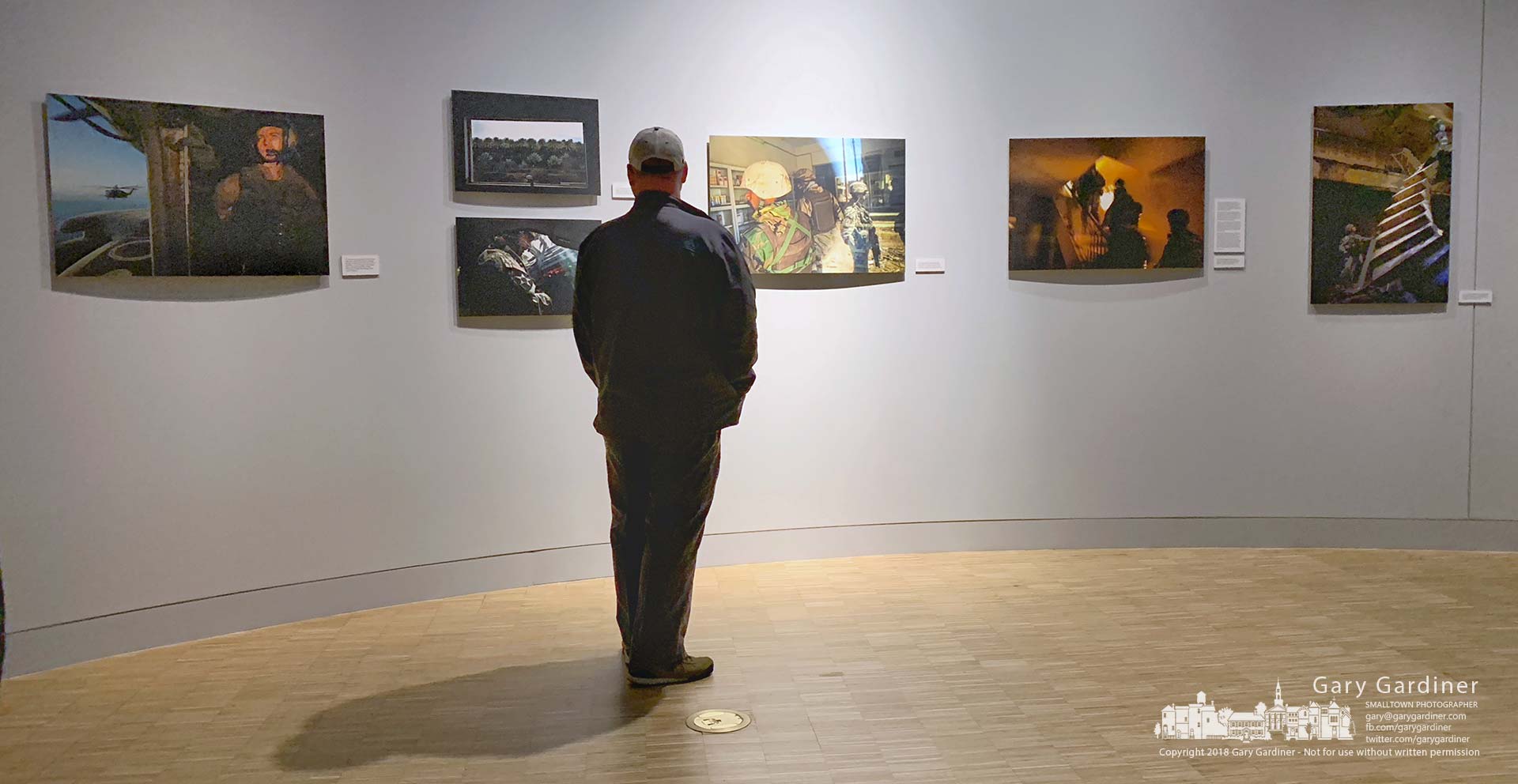 A man pauses to read the notes on Stacy Pearsall's photos hanging in the lower level of the National Veterans Memorial and Museum in Columbus, Ohio, on its opening weekend. My Final Photo for Oct. 28, 2018.