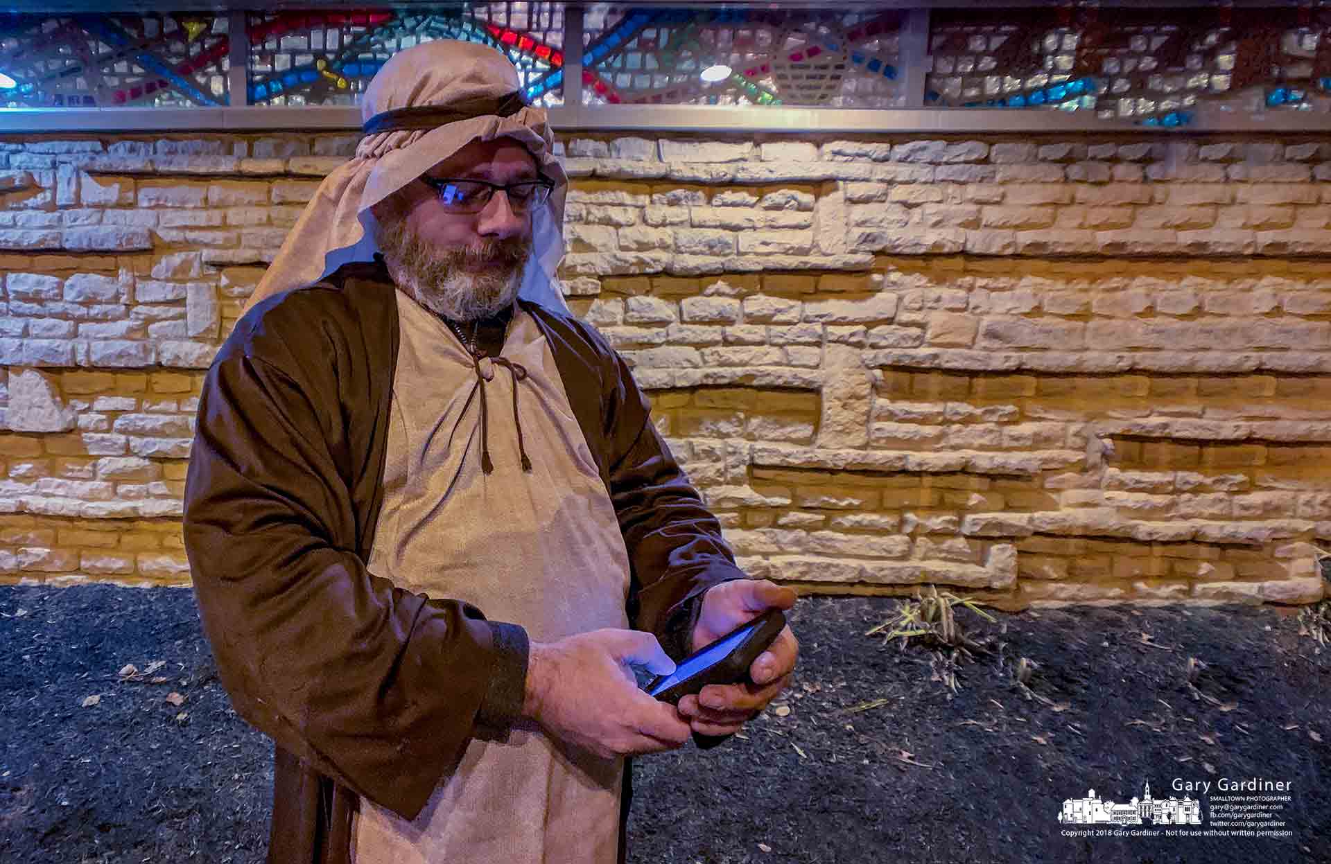 A shepherd takes time to check his smartphone while tending his flock in the living Nativity at the Church of the Messiah on North State Street in Uptown Westerville. My Final Photo for Dec. 14, 2018  