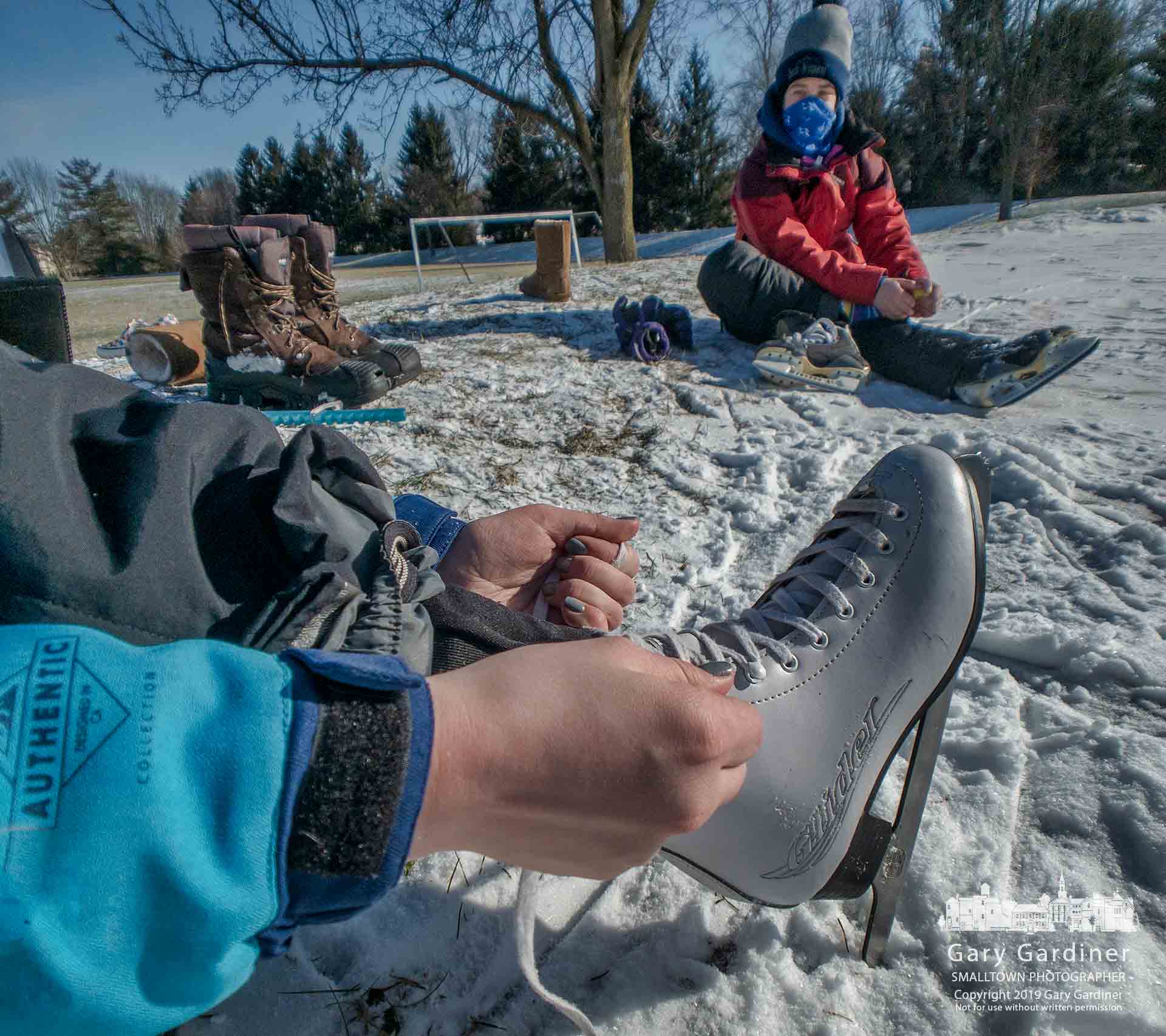 A young girl laces up her skates as she and her friends prepare to skate on the ice rink at Metzger Park. My Final Photo for Jan. 30, 2019.