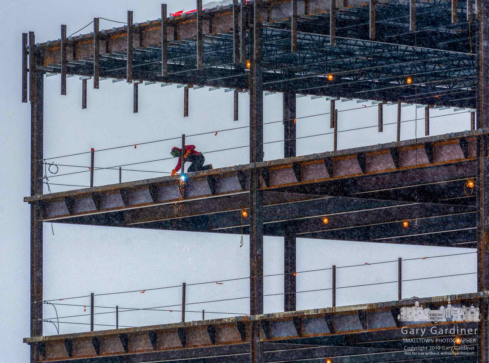 A welder ignores the early morning snow as he anchors mounts for siding on the floor levels of the DHL building being built in the Westar center. My Final Photo for Jan. 17, 2019.