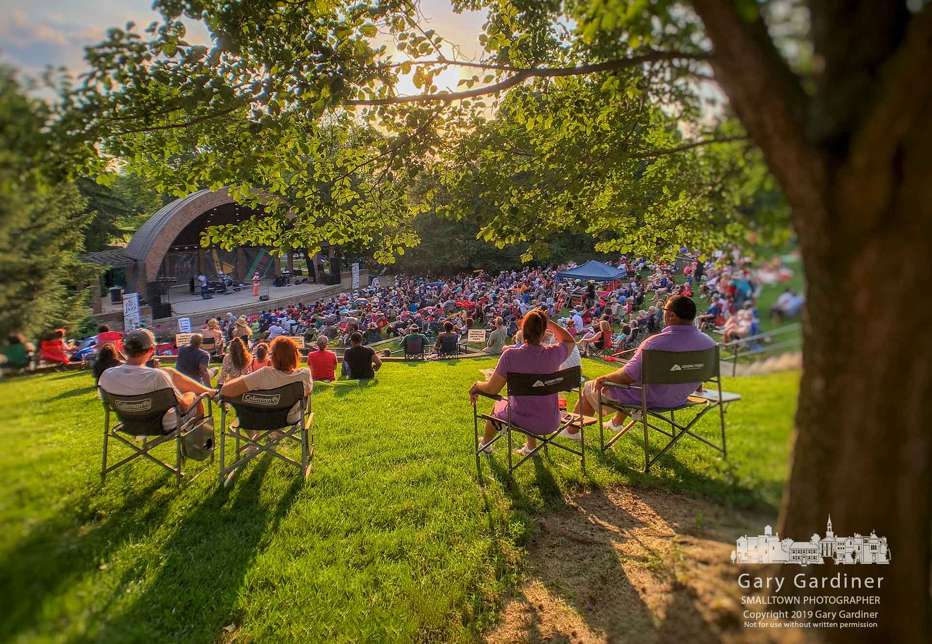 A Saturday evening crowd sits under the setting summer sun listening to jazz played in the amphitheater at Alum Creek Park on West Main in Westerville. My Final Photo for June 29, 2019.