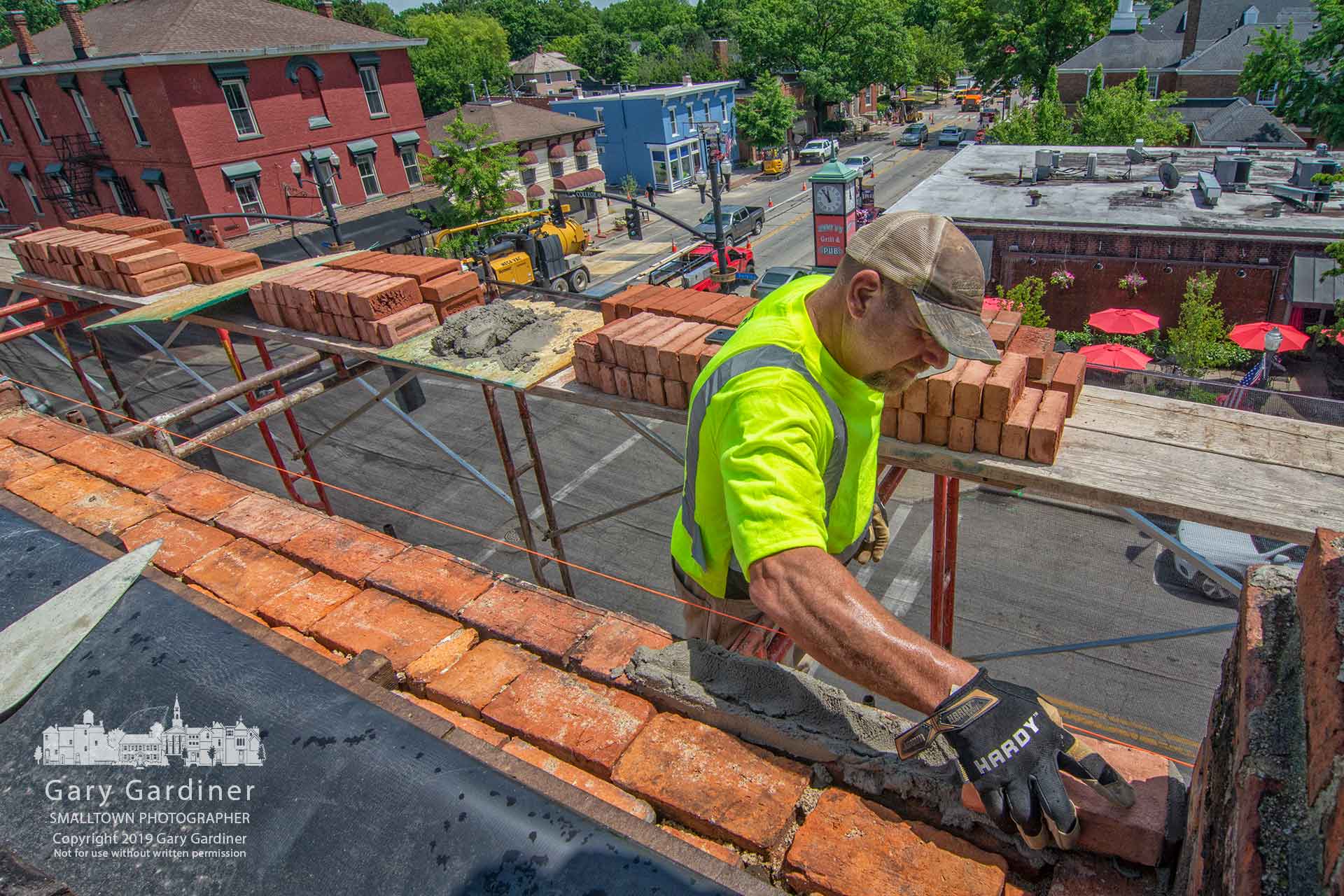 A mason puts in place the first brick to begin repairs to the side of the Cockerell Building on West College after roof repairs revealed loose and damaged bricks. My Final Photo for June 6, 2019.