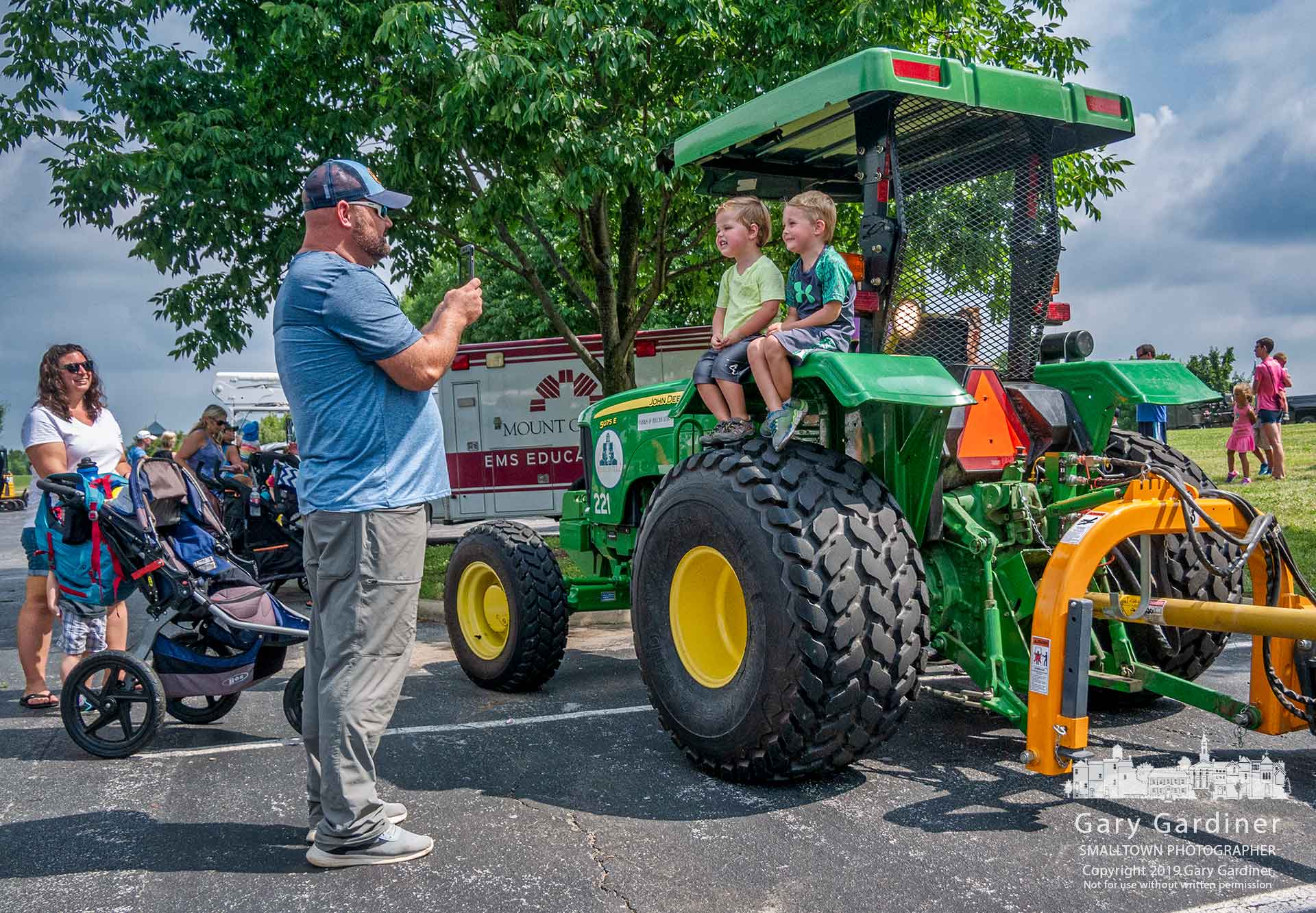 A father photographs his two sons sitting on the rear fender of a Westerville Parks and Recreation tractor during the city's Touch-A-Truck day at the sports fields on Cleveland Ave. My Final Photo for July 19, 2019.