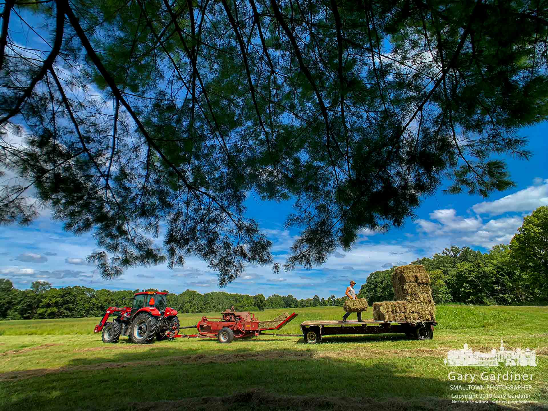 Kevin Scott pulls a hay baler through a field of hay at Polaris and Africa road as Rodney Parker does the difficult chore of properly stacking the hay wagon. My Final Photo for Aug. 25, 2019.
