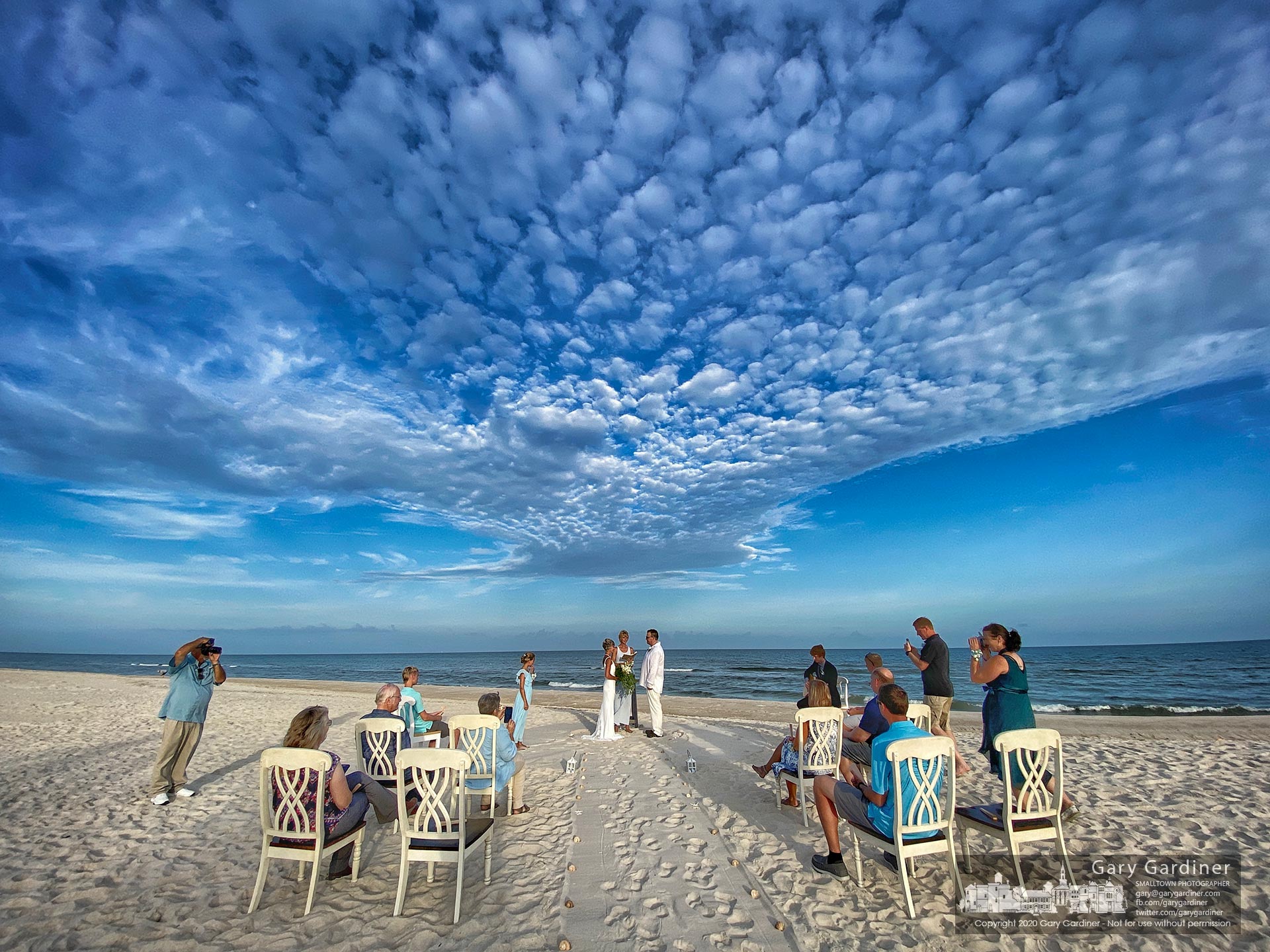 A couple performs their wedding vows at sunset on the beach at St. George Island, FL. My Final Photo for July 14, 2020.